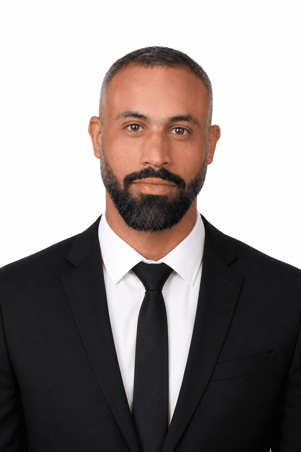 Professional headshot of a bearded man wearing a black suit and tie against white background.